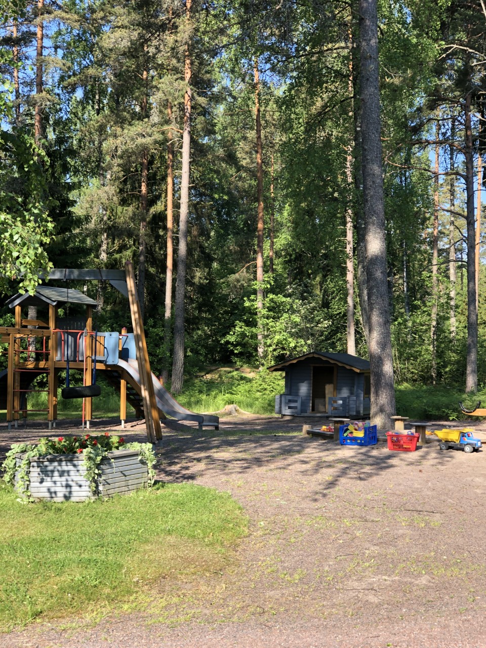 Perhekahvila Drop-In Ulkona Leikkipuisto missä on hiekkalaattikko ja kiipeilyteline ja keinut, kesään aikana