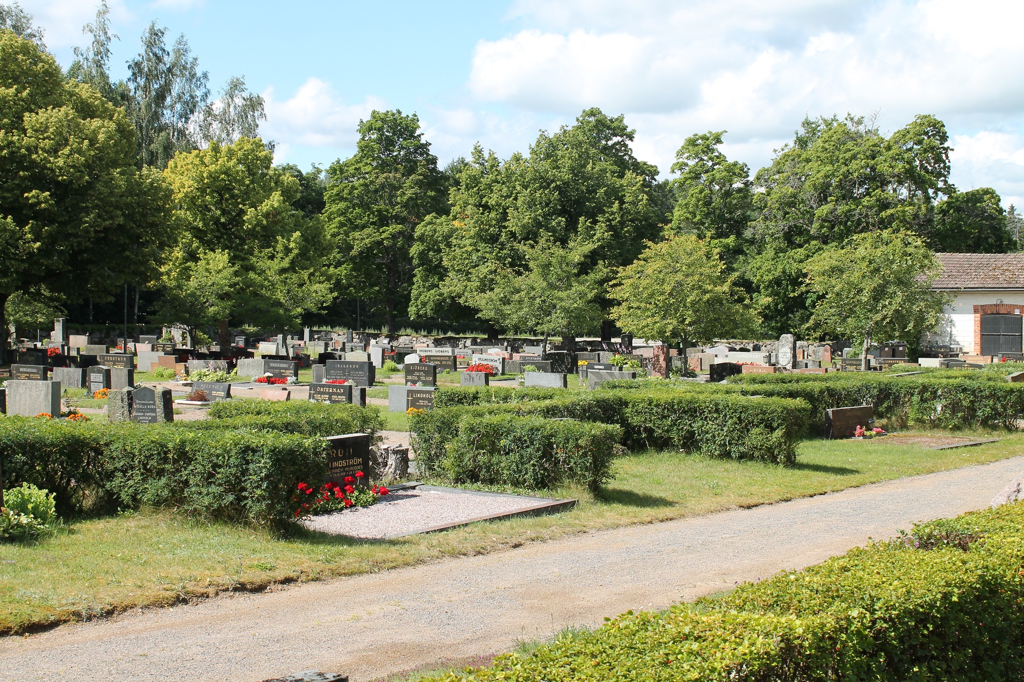 Yleisnäkymä Tenholan hautausmaalle kesäpäivänä, paljon hautoja joille istutettu kukkia.
