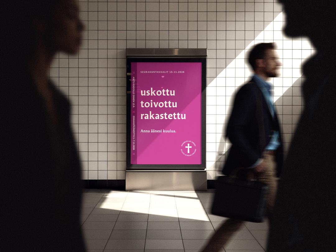 ihmiset kävelevät kadulla, seinällä taulu, jossa lilalla pohjalla lukee Seurakuntavaalit 2026, uskottu, toivottu, rakastettu